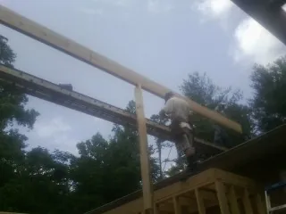 Carpenter setting a ridge beam over a new addition frame — Ice Dam Removal by Roofing Brothers in Croton Falls