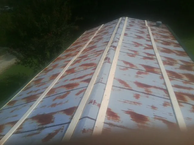 Rusted metal roof panels with new wood purlins before replacement — Storm Damage Roof Repair in Croton Falls by Roofing Brothers