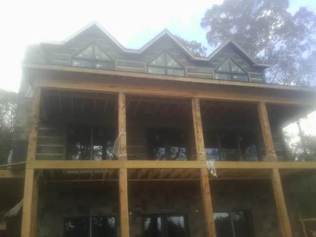 Dormers and porch framing on a large log home under construction — Roof Coating work by our crew in Croton Falls
