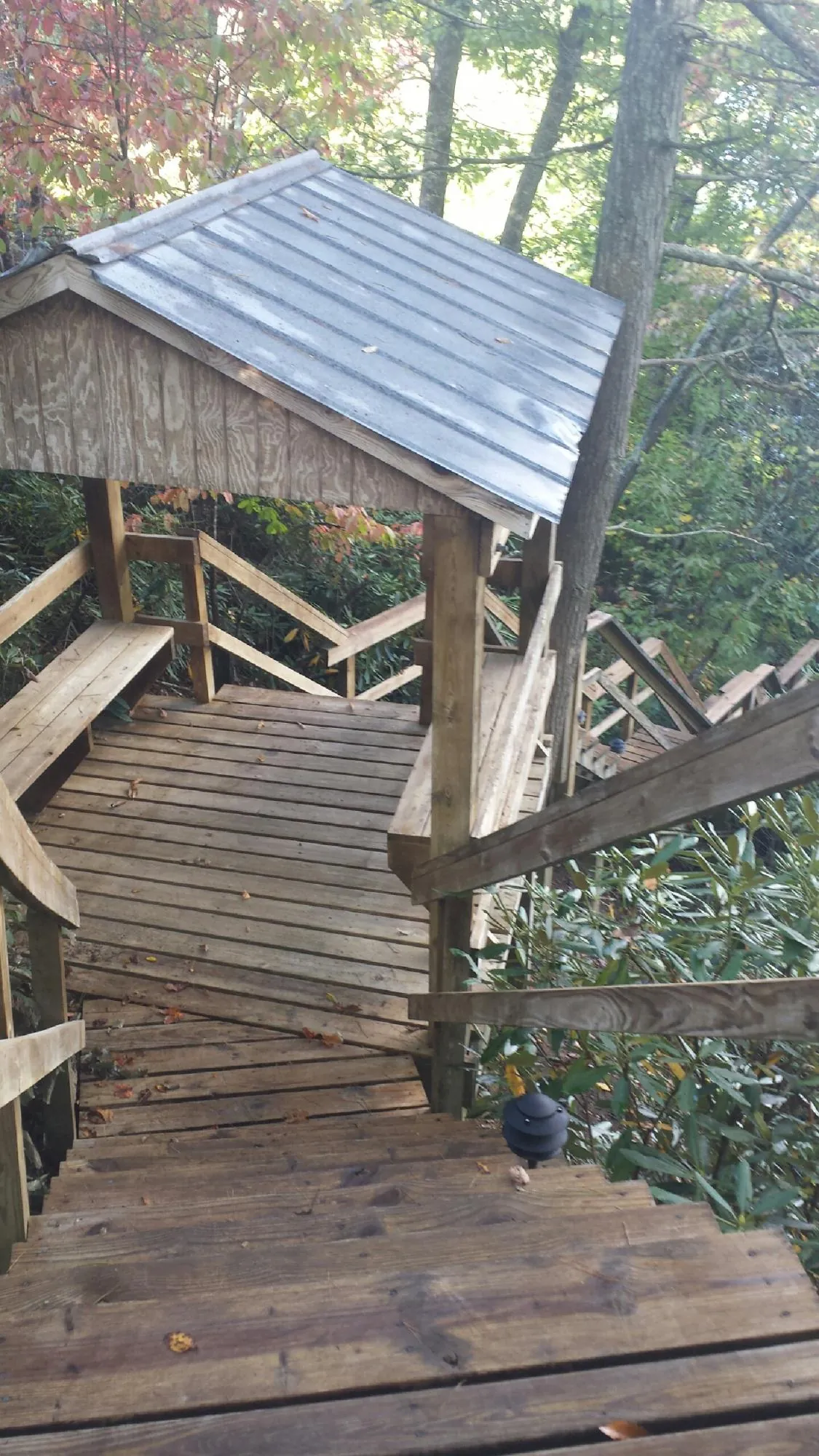 Metal roofed shelter over wooden steps on a wooded walkway — Skylight Repair & Installation work by our crew in Croton Falls