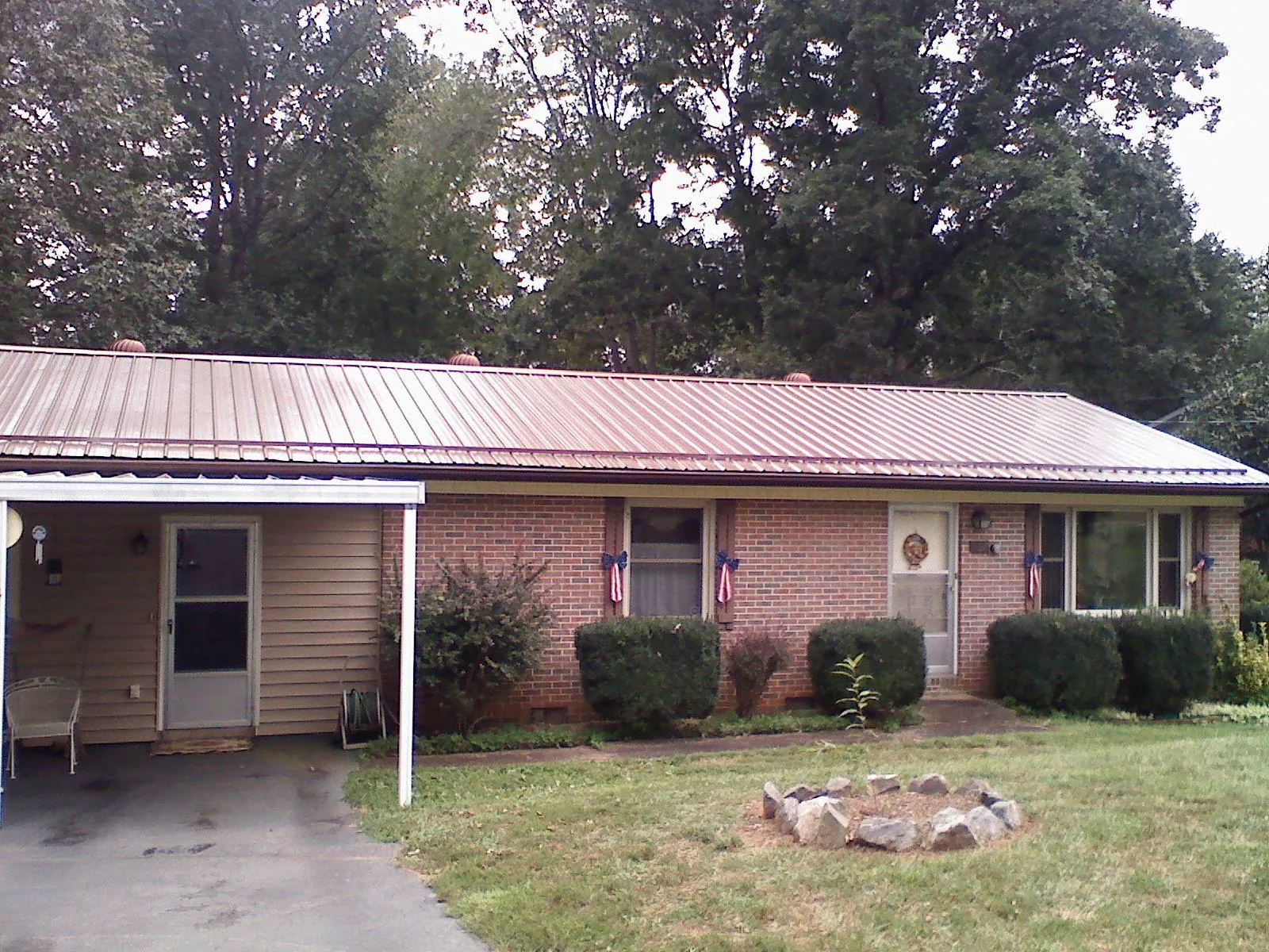 Bronze metal roof and carport on a brick ranch home — Roof Repair work by our crew in Croton Falls